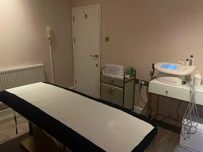 Treatment room set up with a couch, wax heater and advanced facial technology